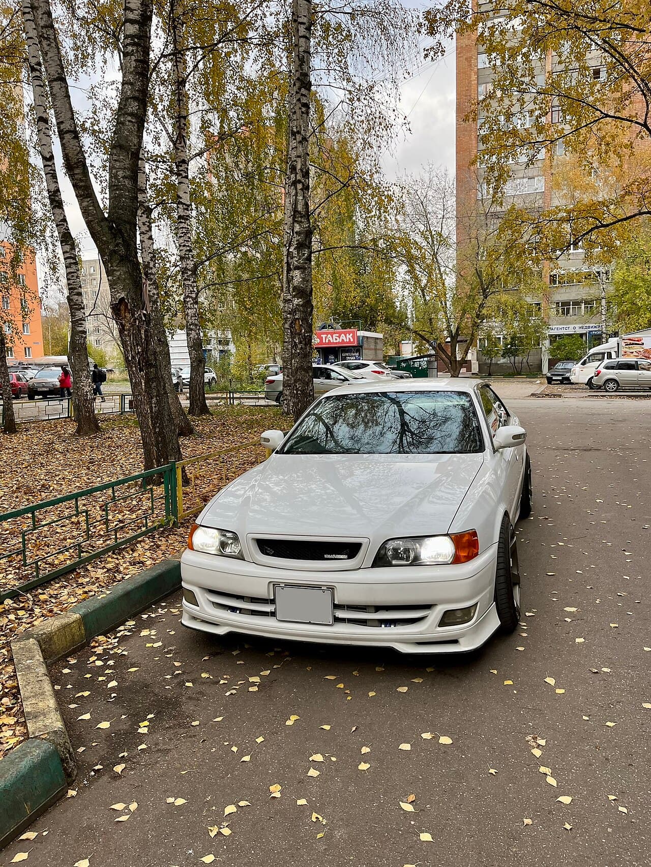 A modified white Toyota Chaser JZX100 Tourer V parked on a residential street, front three-quarter view